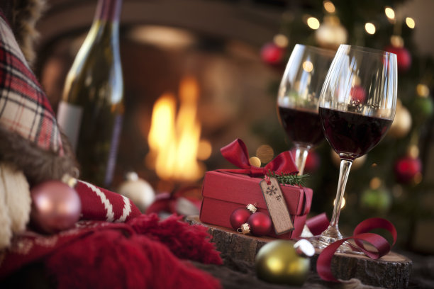 壁炉前的圣诞红酒和圣诞树上的礼物图片下载