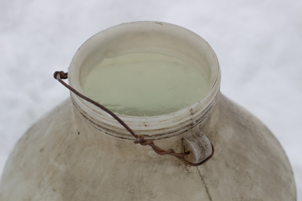 照片冰是装在塑料桶里的。水箱里的水在北方寒冷的秋天结冰了图片下载