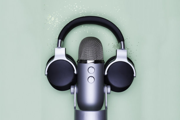 麦克风和耳机放在金灿灿的薄桌子上-专业播客工作室或制作人中心俯视图照片图片下载