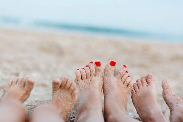 女脚和脚的两个孩子在海的背景。图片下载