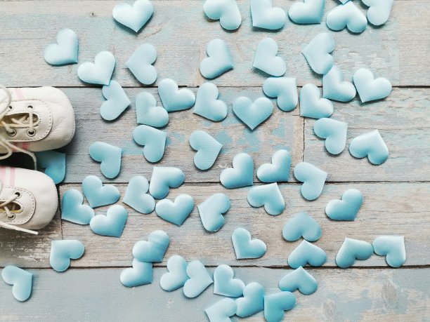 婴儿的靴子和蓝色丝绸心木制的背景，近。图片下载