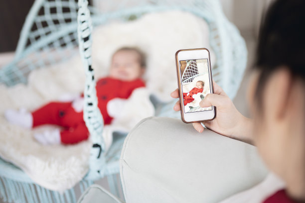 母亲给新生儿拍照图片下载