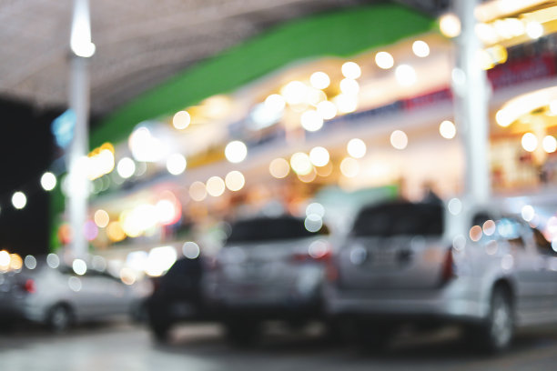 模糊带有停车场的商业大厦的夜灯图片下载