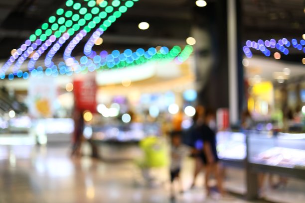 抽象模糊的商业购物商场背景图像与色彩斑斓的灯光室内装饰图片下载