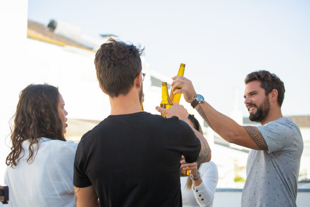 快乐快乐的朋友庆祝成功，举杯畅饮啤酒图片下载