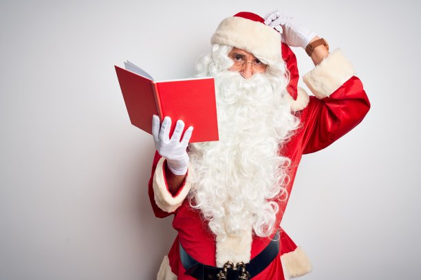 一个中年男人穿着圣诞老人的服装在孤立的白色背景上看书，困惑和疑惑的问题。不确定用怀疑，用手思考。沉思的概念。图片下载
