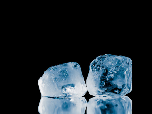 在黑色反光表面背景上的冰块。图片下载