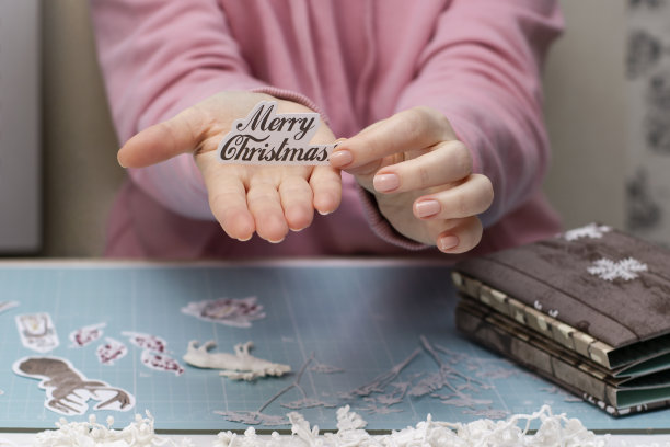 女人的手里拿着一张题词纸Ðerry cristmass。剪贴簿。图片下载