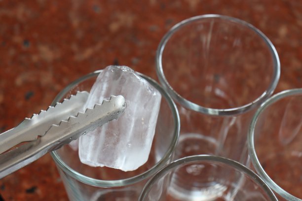 夹上冰块放入玻璃杯中图片下载