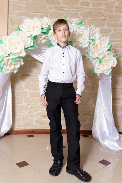 一个年轻男子的肖像在白色衬衫和黑色裤子的背景婚礼拱门图片下载