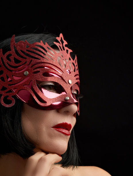 美丽的成年女子白种人外表与黑头发戴着红色闪亮狂欢节面具图片下载