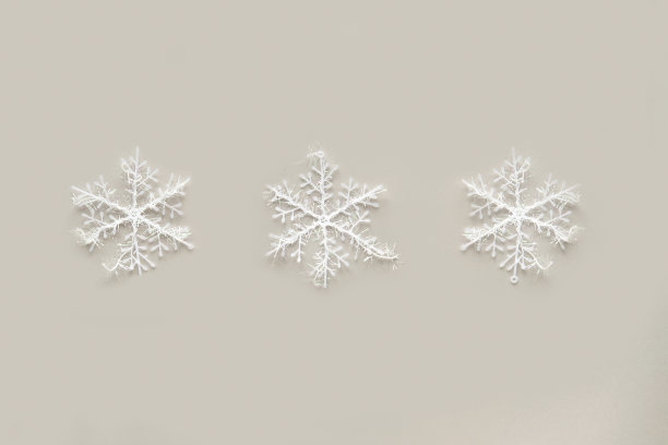 白色的雪花在灰色的背景上。图片下载