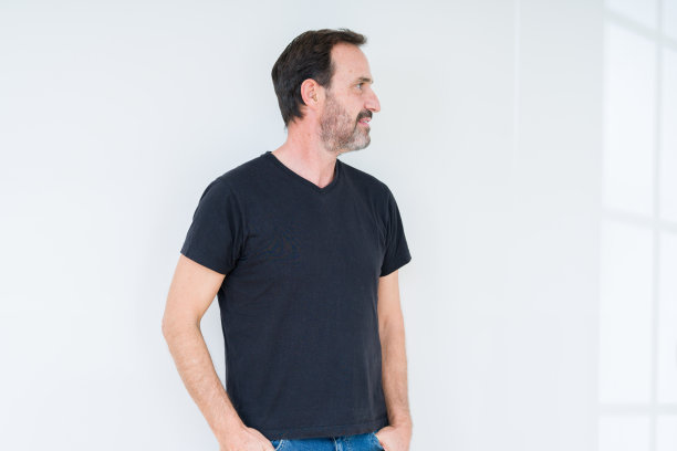 年长男子越过孤立的背景看向一边，放松的侧面姿势，自然的脸上带着自信的微笑。图片下载