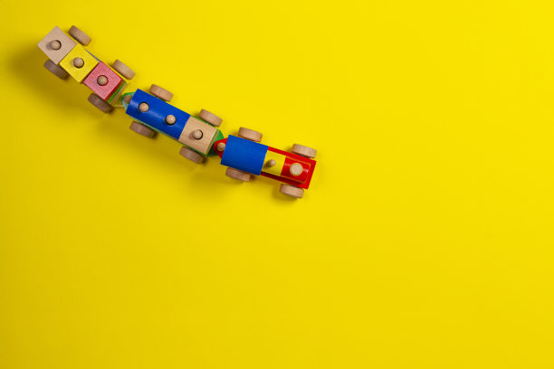 黄色背景上五颜六色的积木木制玩具火车图片下载