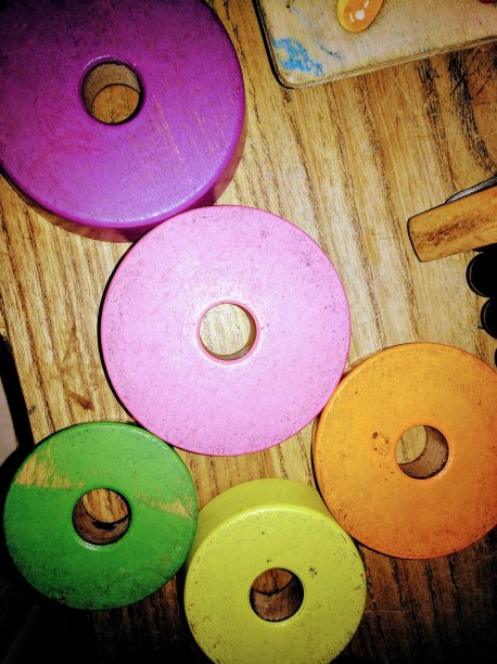 在木制表面上堆叠的玩具环。图片下载