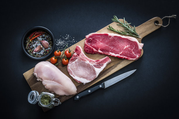 生肉分类-牛肉，鸡肉和猪排从上面拍摄在黑暗的背景图片下载