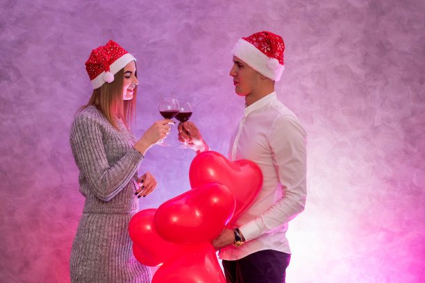 一对幸福的情侣在摆着心形的红色气球图片下载