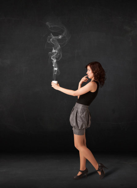 女商人拿着一个白色的冒着蒸汽的杯子图片下载