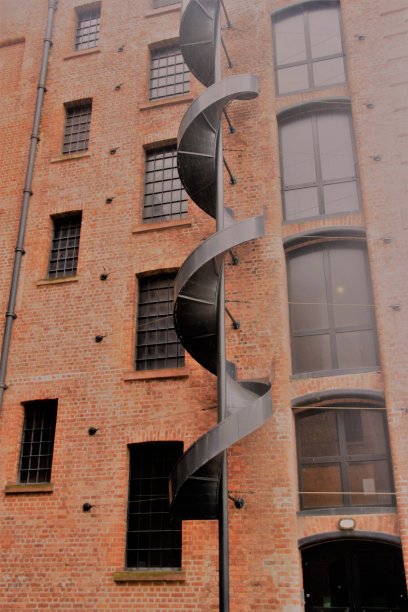 英国利物浦历史悠久的砖石仓库立面，带有螺旋楼梯。图片下载