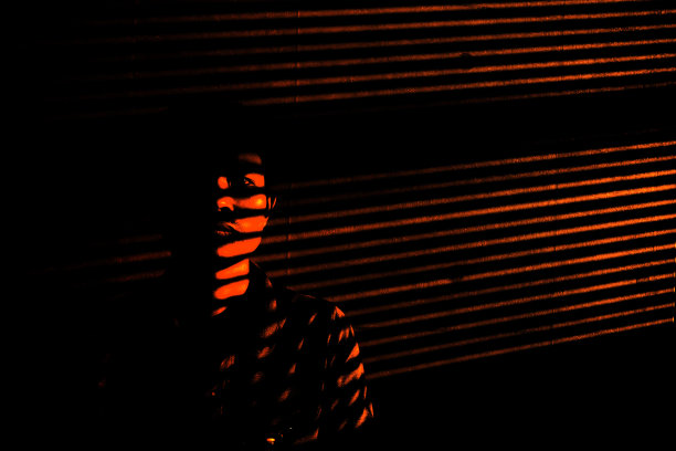 室内设计一个男人的阴影下的美丽图案的阴影在空旷的深色墙壁纹理通过阳光透过窗帘的商业办公室为城市生活方式的理念图片下载