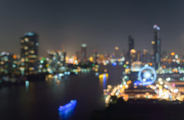 虚景的背景是市中心的摩天大楼。城市的灯光，模糊的照片在晚上的时间。城市景观照明图片下载