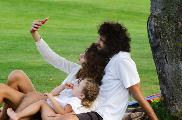 快乐的年轻家庭在公园里图片下载