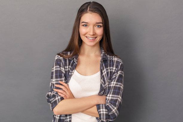 自由泳。年轻女子孤立地站在画室里，灰色的双臂交叉着，笑容可掬图片下载