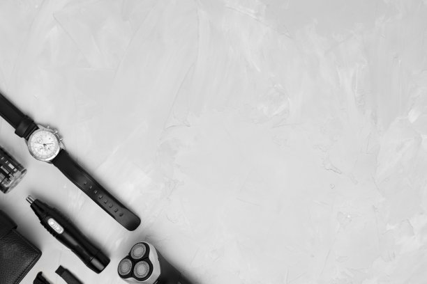 男士配饰:电动剃须刀、修鼻修耳器、须后水、刷子、钱包、手表等都在较轻的表面。早上保健概念。黑白照片。图片下载