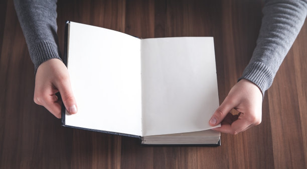 手翻着一本有空白页的书。图片下载