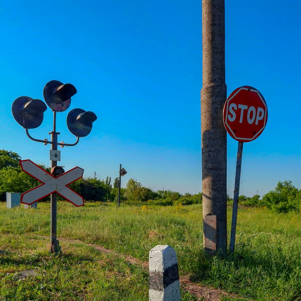 蓝天映衬下的铁路十字路口信号灯。图片下载