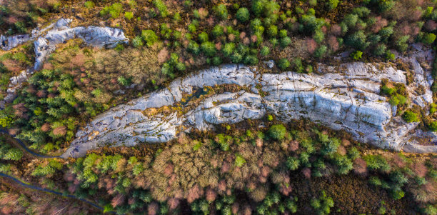 一个晴朗的冬日早晨，苏格兰西南部林区一块巨大的花岗岩露头的鸟瞰图图片下载