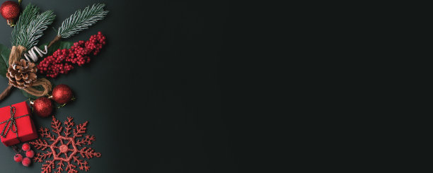 黑色的圣诞背景与红色云杉树枝，圆锥形，云杉玩具，雪花和一个惊喜在礼盒和红色浆果图片下载