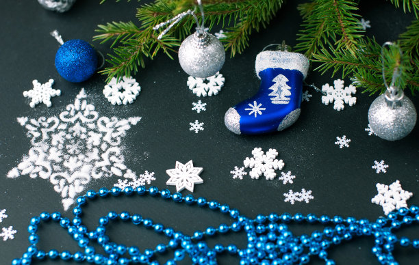 黑色的节日背景与白色和绿色的物体形成对比——天然的绿色云杉枝，白色的雪花，银色闪亮的圣诞玩具图片下载