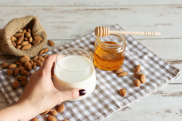 新鲜的有机杏仁牛奶与杏仁坚果和蜂蜜。健康饮食的概念。图片下载