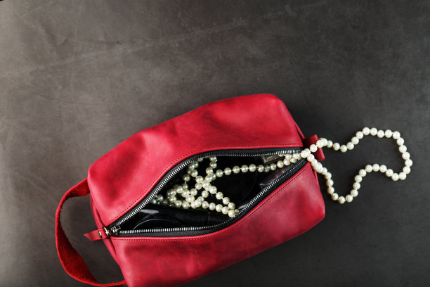 包为化妆品和珠宝制成的真正的红色皮革，在一个黑暗的背景。手工，从上面看图片下载