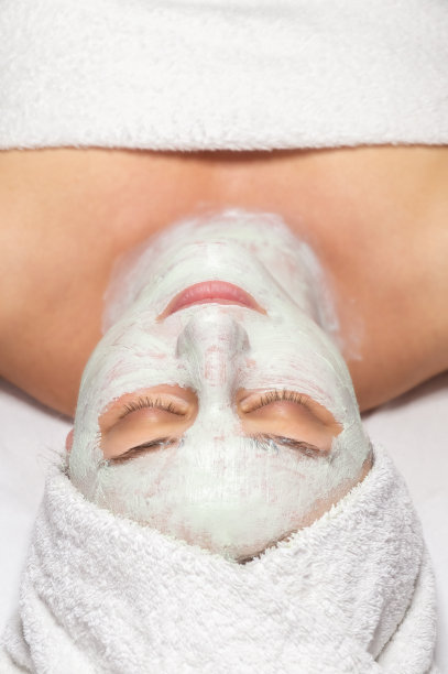 女人躺着，脸上敷着化妆面膜图片下载