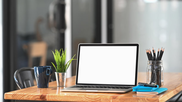 在办公室的工作桌上放笔记本电脑。图片下载