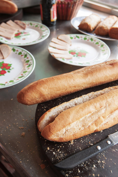 木桌上放着长棍面包和香肠。图片下载
