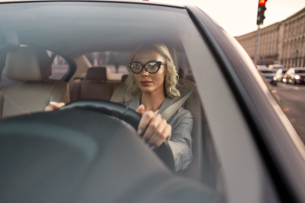 一幅年轻自信的女商人戴着眼镜开车的照片图片下载