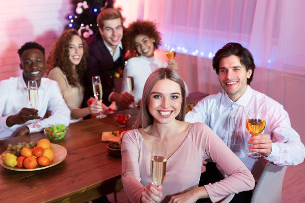 朋友们拿着杯子坐在家里吃圣诞晚餐图片下载