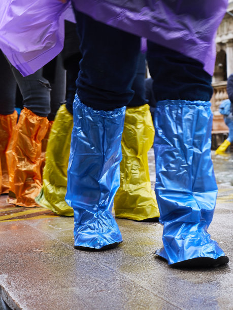 11月，意大利威尼斯，人们穿着五颜六色的一次性塑料靴子在小甲板上行走，圣马可广场被海水淹没图片下载