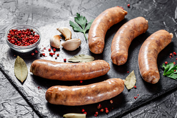 农场的概念，有机产品。生的自制猪肉烧烤香肠放在一块黑石板上。的背景图片。本空间图片下载