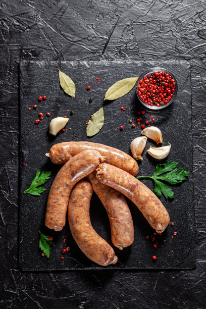 农场的概念，有机产品。生的自制猪肉烧烤香肠放在一块黑石板上。的背景图片。本空间图片下载