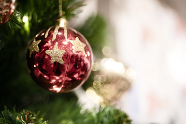 近距离装饰红色的小玩意装饰在绿色的圣诞树或松树与散焦模糊的灯光散焦背景和复制空间。图片为平安夜和新年的概念。图片下载