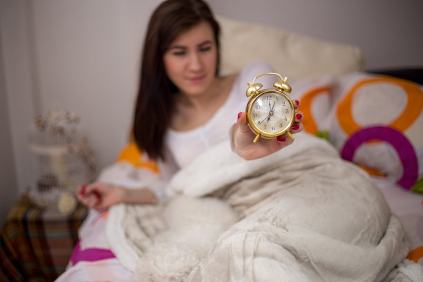 一个年轻女人和她的狗在床上。图片下载