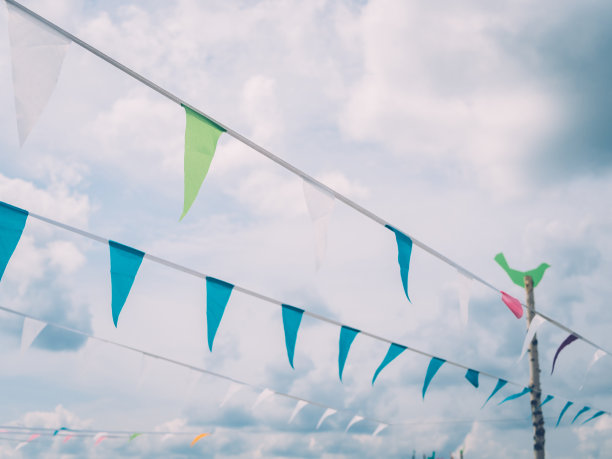 在夏季节日期间，悬挂在绳索上的三角旗抵着云雾图片下载