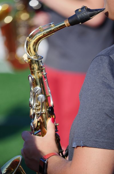 一位手持萨克斯管的女乐队手，散音在背景中图片下载