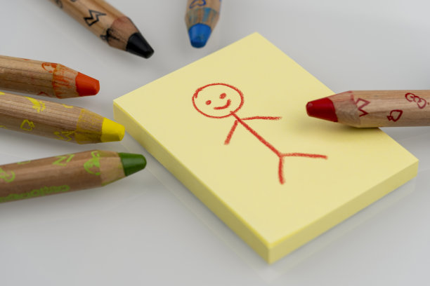 Stickman用彩色铅笔在黄色粘纸上画画图片下载