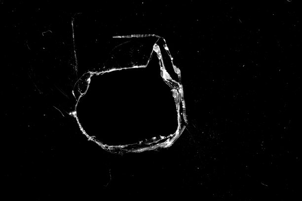 黑色背景上玻璃上的洞和裂缝。图片下载
