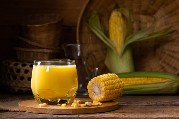 新鲜甜玉米汁(玉米奶)和玉米在木材背景图片下载